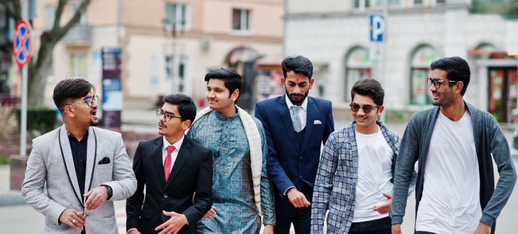 Group of stylish men walking together on a city street